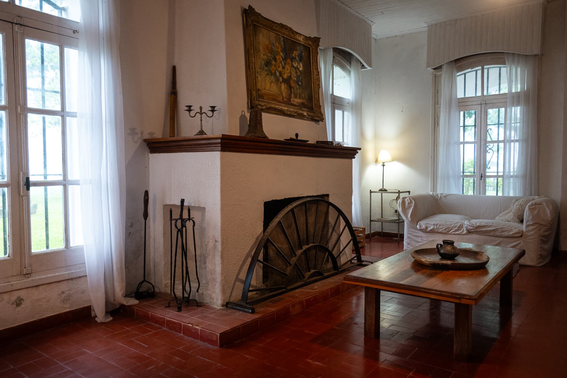 Living del casco con hogar a leña y muebles antiguos